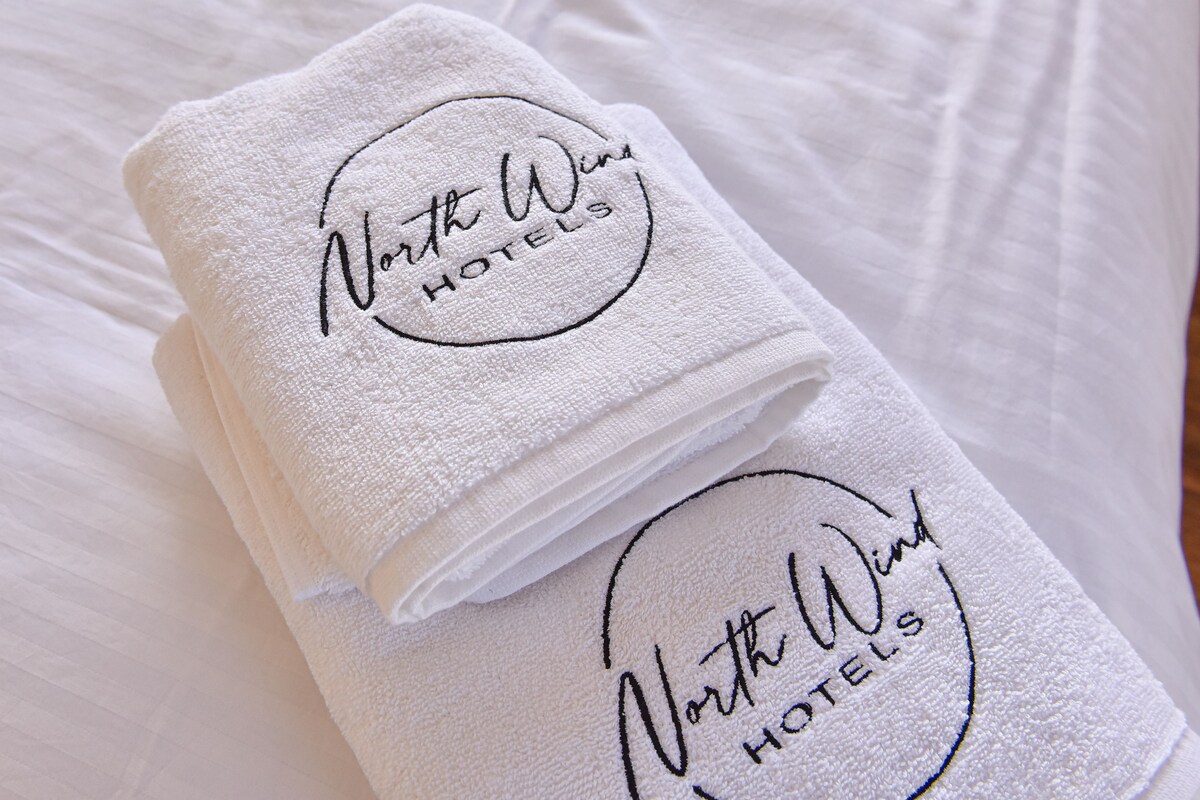 Dos toallas blancas dobladas con el bordado 'North West Hotels'.
