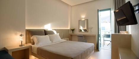 Un hotel moderno con cama, mesita de noche, lámpara, espejo, televisor y vistas al exterior.