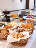 A buffet with various breads and pastries.