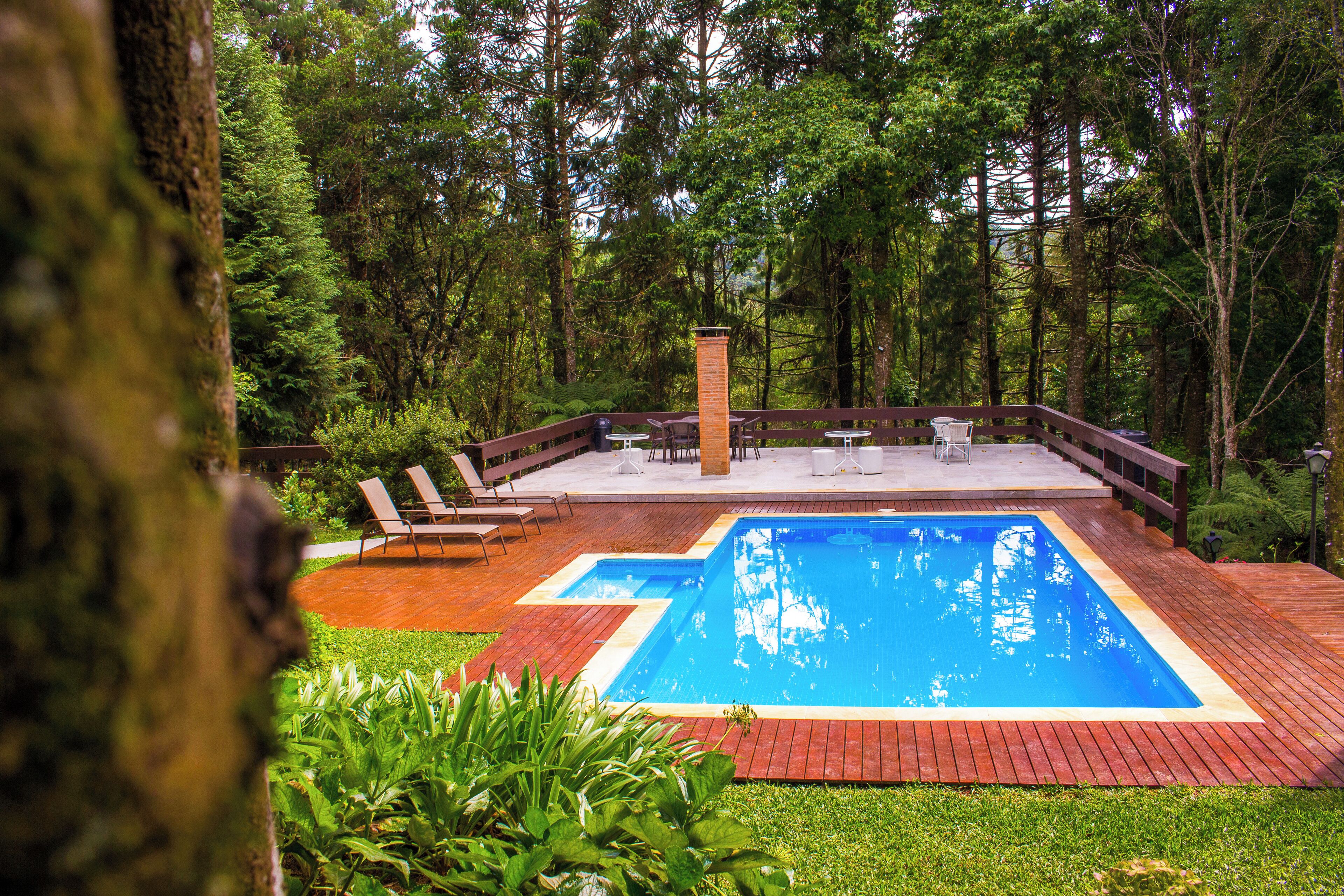 Una piscina al aire libre, sombrillas, tumbonas