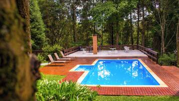 Una piscina al aire libre, sombrillas, tumbonas