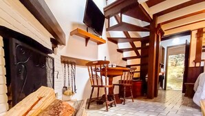 A rustic interior with a fireplace, wooden furniture, and a television mounted on the wall.