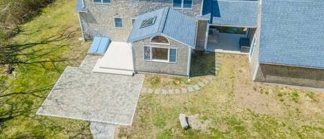 A two-story house with a covered patio and a fire pit.