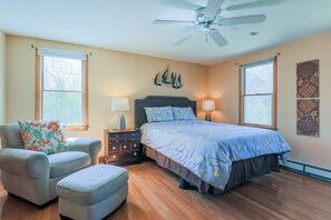 A bedroom with a bed, a chair, a nightstand, and a ceiling fan. - Book Eastham, Plenty Of Room For Entire Family! (Eastham)