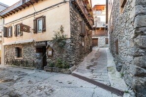 Une rue étroite bordée d’immeubles en pierre, dont l’un porte une enseigne indiquant « La Estrellita ».