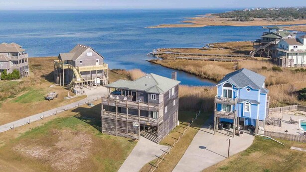 A coastal residential area with houses, a dock, and a view of the ocean. - Soundfront DogFriendly w Hot Tub, EV Charger, Private Sound Access, Beach Nearby (Frisco)