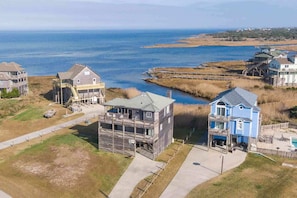 A coastal residential area with houses, a dock, and a view of the ocean.
