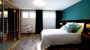 Ein Schlafzimmer mit Bett, Stuhl, Kleiderschrank und Fenster.