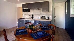 A modern kitchen with dark cabinets, a microwave, and a coffee maker. - T2 Orly center ville Close to Paris and shops (Orly)