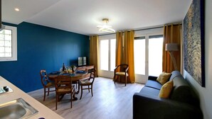 A dining area with a table set for four, a sofa, and a television. - T2 Orly center ville Close to Paris and shops (Orly)