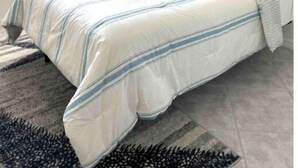 Une chambre à coucher avec un lit, une table de chevet, une lampe, un ventilateur de plafond, une fenêtre et un tableau accroché au mur.