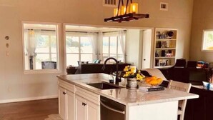 A kitchen with a central island, white cabinetry, a dishwasher, and a hexagonal tile floor. - A Modern-Rustic Lake Retreat Get-Away! (Milledgeville)