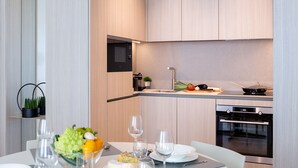 Una cocina moderna con microondas integrado, horno y una pequeña encimera con una planta y una olla.