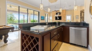Una cocina moderna con una isla grande, electrodomésticos de acero inoxidable y vistas al exterior.