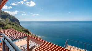 Una terrazza con vista sul mare, una piscina e un paesaggio montuoso.