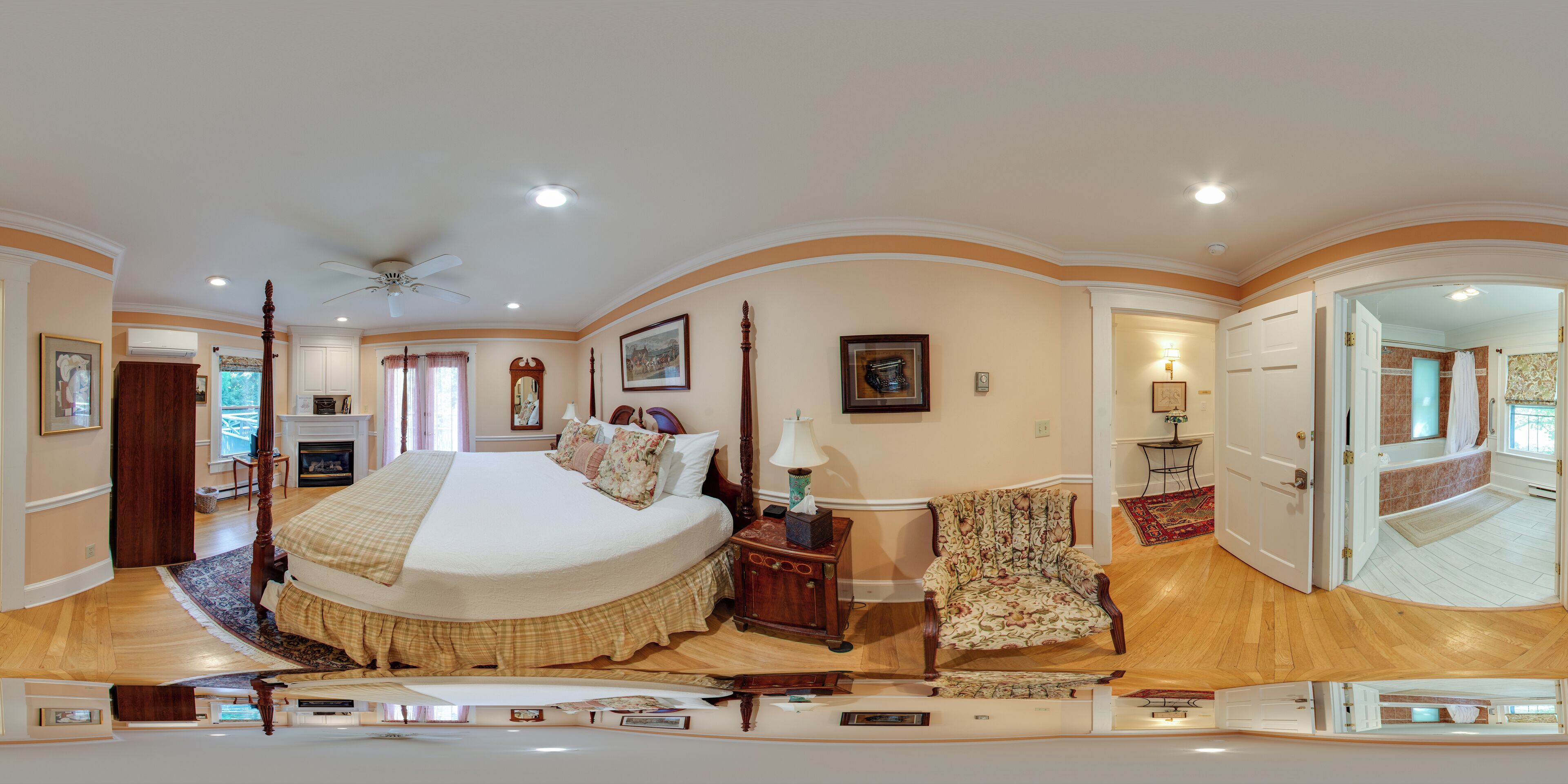 A spacious bedroom with a large bed, a wooden nightstand, a chair, and a mirror.