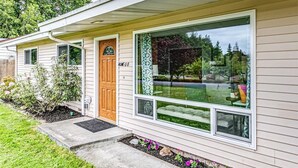 A single-story house with a front door, large windows, and a small porch area. - Olympic  Adventure Home, Your Gateway To Adventure And Olympic National Park (Port Angeles)