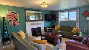 A living room with a fireplace, a sofa, a coffee table, and a television. - Olympic  Adventure Home, Your Gateway To Adventure And Olympic National Park (Port Angeles)