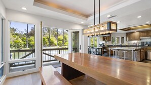 A modern kitchen with a large island, wooden cabinets, and a view of the outdoors. - Pitchouline Estate @ Vineyard & Olive Grove by Fallbrook, Temecula Wine County (Fallbrook)