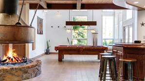 A spacious interior with a stone fireplace, wooden beams, and a pool table. - Pitchouline Estate @ Vineyard & Olive Grove by Fallbrook, Temecula Wine County (Fallbrook)