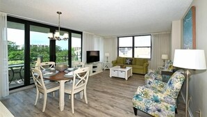 Ein geräumiges Wohnzimmer mit Essbereich, einer Couch und einem Fernseher.