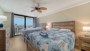 A hotel room with two beds, a ceiling fan, a balcony with a view, and a wooden headboard. - Anchorage 405 (Siesta Key)