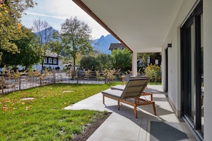 Un patio con una poltrona da relax, un tavolino e vista su una montagna.