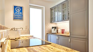 Una cocina moderna con encimera de madera, horno empotrado y cafetera.