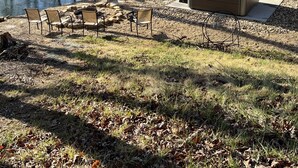 A backyard with a hot tub, outdoor seating, and a view of a river. - Serenity, Waterfront Mountain Retreat (Eagle Rock)