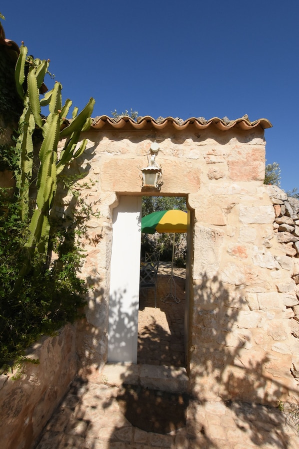 A stone building with a tiled roof and a doorway.