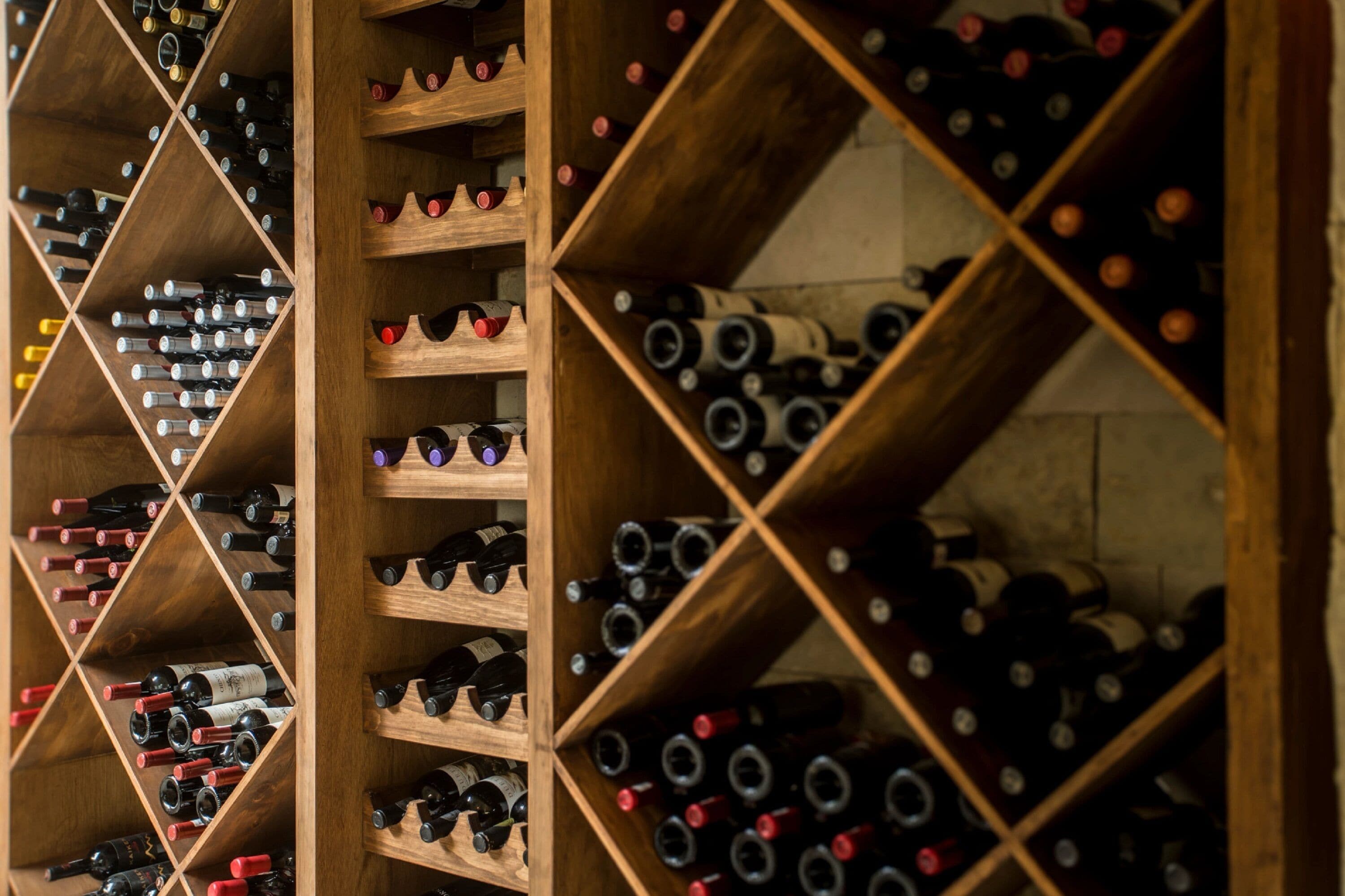 Una celler de vi amb prestatges i amples d'obra que contenen nombroses ampolles de vi.