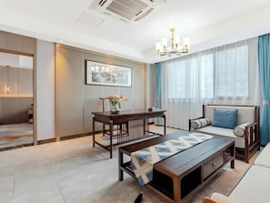 A modern hotel room with a dining table, sofa, and a large window with curtains. - Greentree Eastern Chizhou Changjiang Middle Road Rt-mart Hotel (Chizhou)