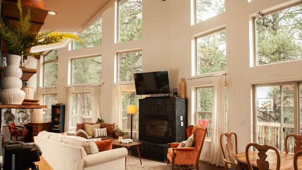 A spacious living room with a fireplace, large windows, and a cozy seating area. - The Toho-Tally Toho-Tel (Flagstaff)