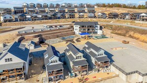 A residential area with multi-story houses, a swimming pool, and a basketball court. - Lakeview Retreat with Private Firepit, Pinball, Backyard, Hot Tub, Free Tickets & Steps to Amenities (Branson)