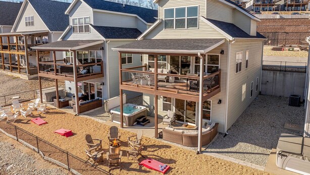 A row of beach houses with outdoor seating and a hot tub. - Lakeview Retreat with Private Firepit, Pinball, Backyard, Hot Tub, Free Tickets & Steps to Amenities (Branson)