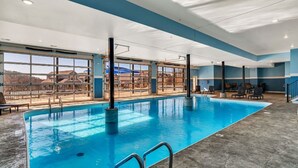 An indoor swimming pool with clear glass walls, a view of the outside, and a concrete floor. - Lakeview Retreat with Private Firepit, Pinball, Backyard, Hot Tub, Free Tickets & Steps to Amenities (Branson)