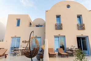 A modern building with a flat roof, large windows, and a balcony with wooden railings. - Pink Freud Villas Santorini (Santorini)