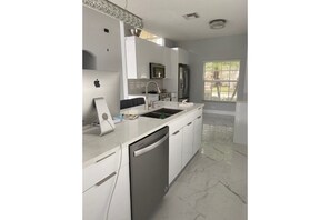 Enjoy cooking in this well-lit kitchen with a stainless steel refrigerator, dishwasher, and modern cabinetry.