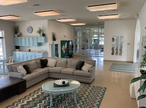 Relax in this stylish living room with a large L-shaped sofa, glass coffee table, and adjacent kitchen view.