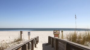 A wooden boardwalk leading to a beach with clear skies. - Shoalwater 106 | Beachfront Corner Condo | Indoor, Outdoor Pools | My Beach Getaways (Orange Beach)