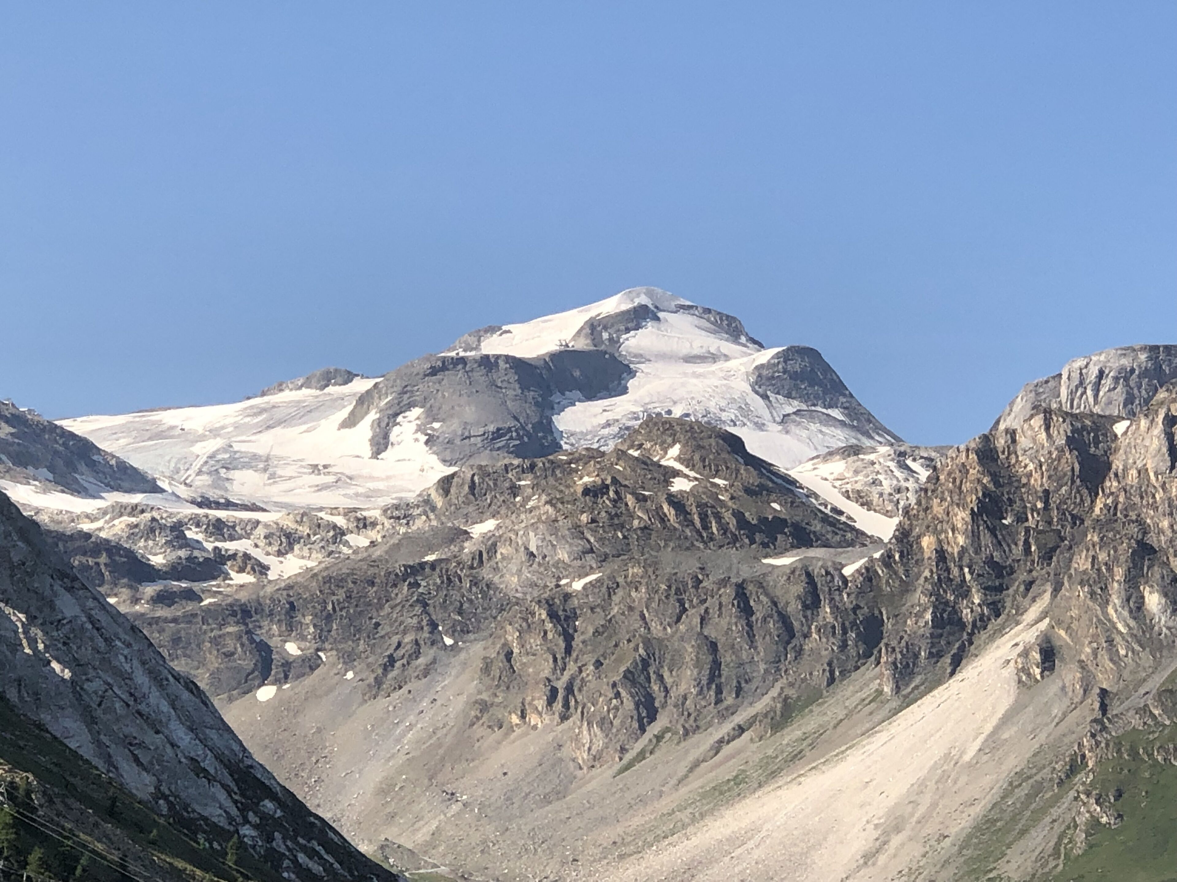 Une montagne aux sommets enneigés et au terrain rocheux.