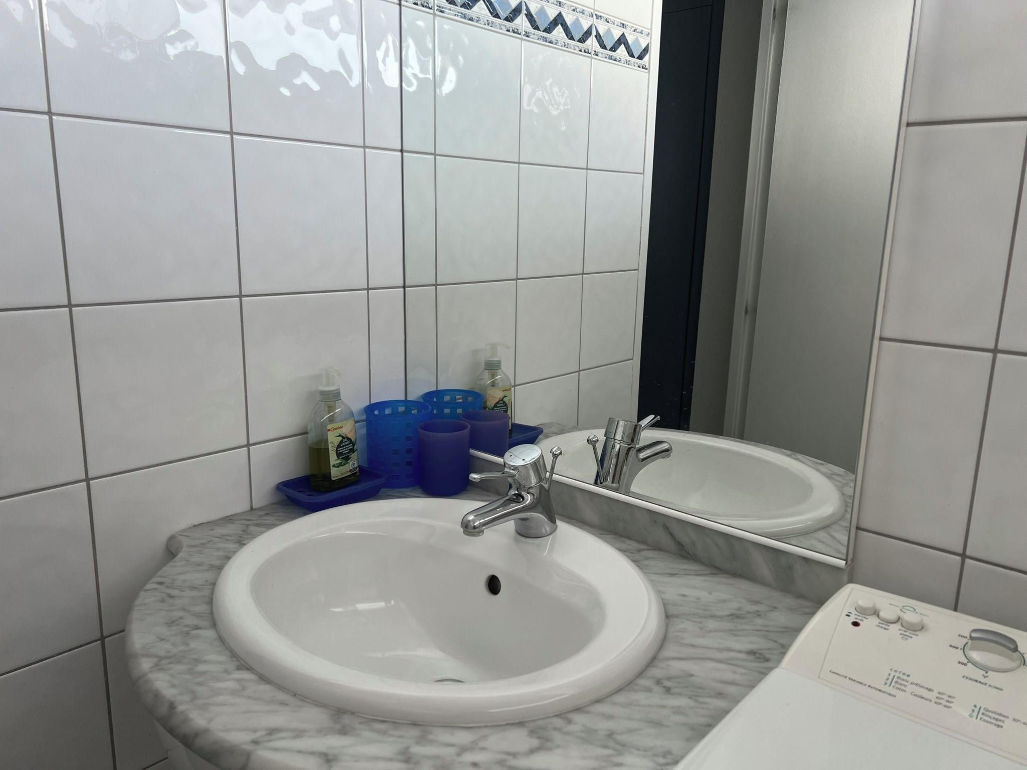 A bathroom with two sinks, a mirror, and toiletries on the counter.