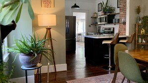 A modern kitchen with a central island, a dining area with chairs, and a living space with a sofa. - Sunny Stifft’s Station/Capital View: Off Street Parking AT&T Fiber (Little Rock)