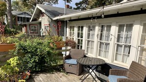 A wooden deck with wicker furniture, a table, and chairs. - Sunny Stifft’s Station/Capital View: Off Street Parking AT&T Fiber (Little Rock)