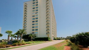 Un grand hôtel moderne doté de nombreux balcons et d’une pelouse bien entretenue.