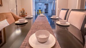 A dining area with a round table, chairs, and a chandelier. - Retreat in the woods! (Houston)