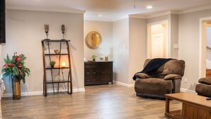 A living room with a brown leather sofa, a wooden coffee table, and a dark wooden cabinet. - Retreat in the woods! (Houston)