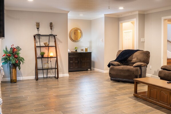 A living room with a brown leather sofa, a wooden coffee table, and a dark wooden cabinet.