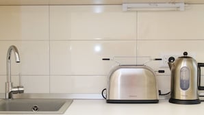 A kitchen with a Kenwood toaster, a kettle, and an Elin dishwasher. - Apartment Jovanova (Belgrade)