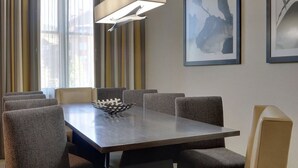 A conference room with a rectangular table, eight upholstered chairs, a modern pendant light, and framed artwork on the walls. - Stay and Ski in Northstar Resort (Truckee)